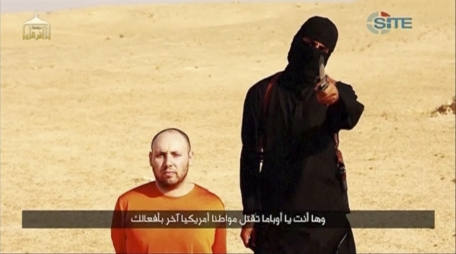 A masked, black-clad militant, who has been identified by the Washington Post newspaper as a Briton named Mohammed Emwazi, stands next to a man purported to be Steven Sotloff in this still image f ...