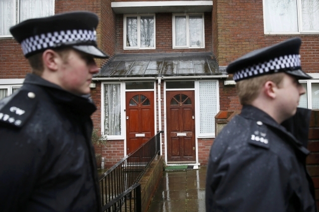 Two police officers walk outside a flat in London Feb. 26, 2015. Local media reported that the flat is the former home of  Mohammed Emwazi. Investigators believe that the "Jihadi John" masked figh ...