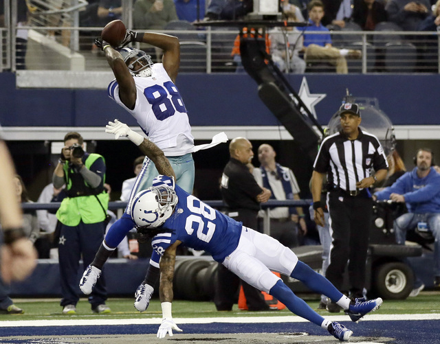 Dallas Cowboys wide receiver Dez Bryant (88) reaches up to grab a touchdown pass over Indianapolis Colts cornerback Greg Toler (28) during the first half of an NFL football game, Dec. 21, 2014, in ...