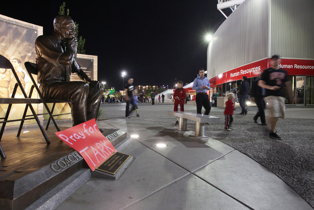 A sign wishing former UNLV basketball coach Jerry Tarkanian well rests on a sculpture of him in front of the Thomas & Mack before the Rebels game against Fresno State Tuesday, Feb. 10, 2015. (Sam ...