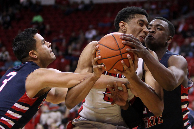 UNLV forward Christian Wood is double teamed by Fresno State guard Cezar Guerrero, left, and Fresno State guard Marvelle Harris during the second half of their Mountain West Conference game Tuesda ...