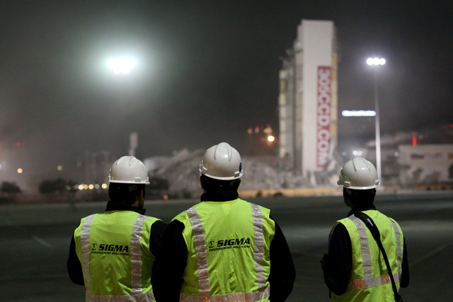 Members of demolition team stand looking at the segment of the Clarion Hotel and Casino that failed to fully implode on Tuesday, Feb. 10, 2015. (Michael Quine/Las Vegas Review-Journal)