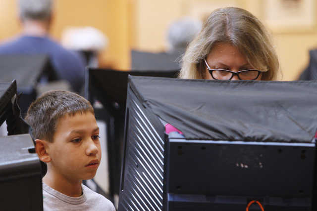 Logan Martinez watches as his mother Renee Martinez votes during early voting at the Galleria Mall in Henderson Saturday, Oct. 18, 2014.  (Sam Morris/Las Vegas Review-Journal)