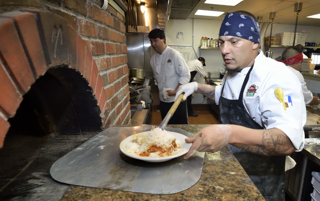 Pizza chef James Jones prepares to slide a lasagna plate into the wood-burning brick oven in the kitchen at Gabriella's Italian Grill and Pizzeria at 8878 S. Eastern Ave. in Las Vegas on Saturday, ...