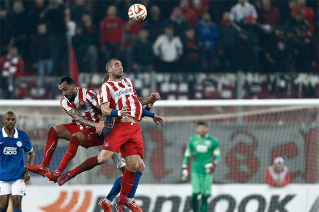 Olympiakos' Pajtim Kasami, right, and Kostas Mitroglou jump to head the ball during their Europa League round of 32 second-leg soccer match against Dnipro at Karaiskaki stadium in Piraeus, near At ...