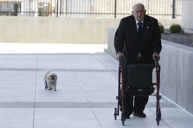 Salvatore Ruvolo, co-defendant in a federal case involving fraud and corruption at Las Vegas homeowners associations, walks to Lloyd George Federal Courthouse in Las Vegas with his dog Scooter Wed ...