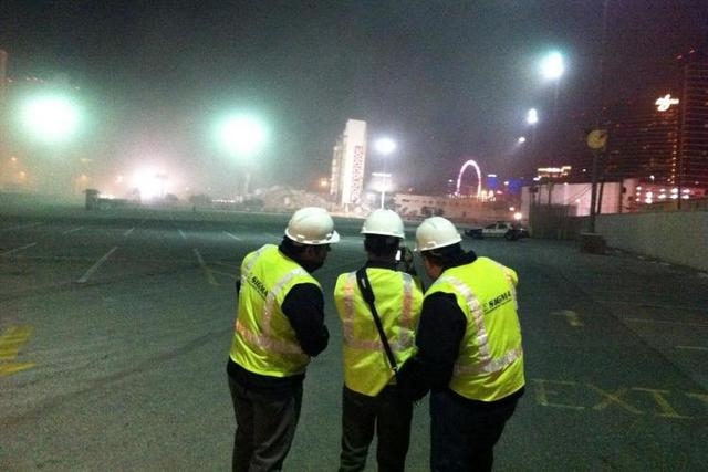 Members of the demolition crew look on following the implosion of the Clarion Hotel and Casino, which left the elevator shaft standing  in the early morning hours of Tuesday, Feb. 10, 2015. (Micha ...