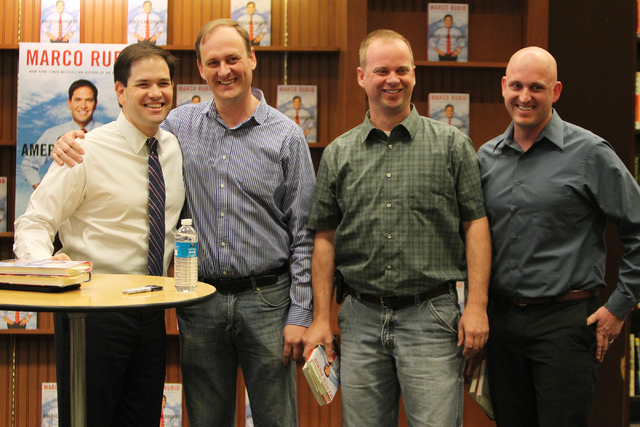 U.S. Sen. Marco Rubio, R-Fla., from left, poses for a photo with his childhood friends from left, Bryan Thiriot, and his brothers Nathan, and Bryce during a book signing of his book, American Drea ...