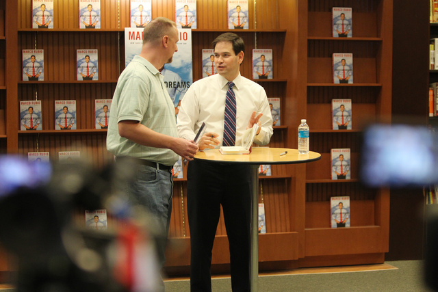 U.S. Sen. Marco Rubio, R-Fla., right, signs his book for Ryan Brooks, government teacher at Cimarron High School, during a book signing of his book, American Dreams: Restoring the Land of Opportun ...