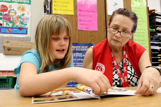 Katie Samson, 8, sits and reads "The Plot Chickens" with Mary Astorga as part of the Foster Grandparent Program to help children learn to read at the Richard Rundle Elementary School in Las Vegas. ...