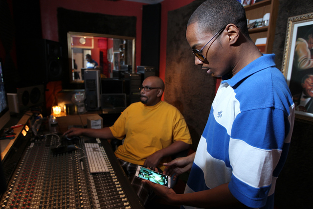 Kenneth Borner, right, also known as Wordz, checks his phone during a recording session with his music producer Silas Washington at his studio in Las Vegas Thursday, Feb. 12, 2015. Borner, 27, a C ...