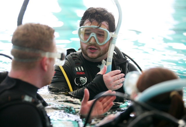 Levi Henley, center, Scuba Views scuba diving instructor, works with students Trevor Workhoven, left, and Jennie Day, right, during a scuba diving lesson at Las Vegas Municipal Pool Wednesday, Feb ...