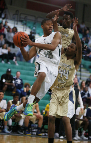 Palo Verde's Ja Morgan, left, jumps up with the ball before passing it around Shadow Ridge's Melvin Johnson, center, and Ray Perkins, right, during a basketball game at Palo Verde High School Tues ...
