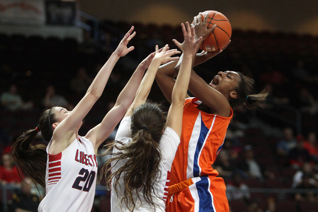 Bishop Gorman forward Madison Washington shoots over Liberty guards Kealy Brown, left, and CeCe Quintino during their Division I state semifinal game Thursday, Feb. 26, 2015, at the Orleans Arena. ...