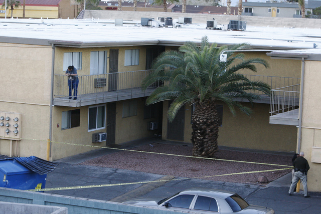 Las Vegas police officers investigate the scene of a shooting at the Siegel Suites apartments near the intersection of E. Twain Avenue and Swenson Street in Las Vegas Tuesday, Feb. 24, 2015. (Erik ...