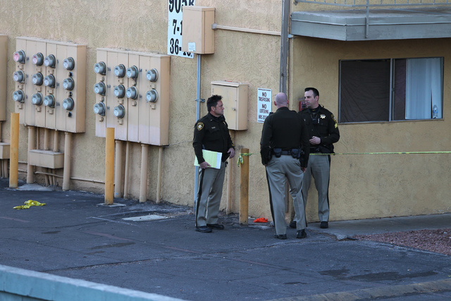 Las Vegas police officers investigate the scene of a shooting at the Siegel Suites apartments near the intersection of E. Twain Avenue and Swenson Street in Las Vegas Tuesday, Feb. 24, 2015. (Erik ...