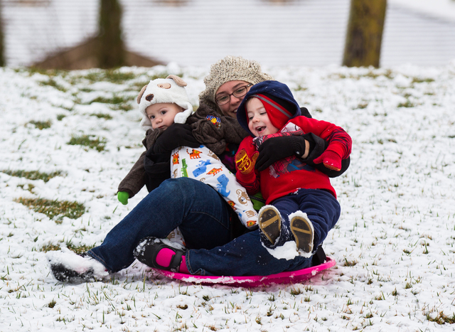 Audra Omlie slides down a hill with her children Rowen, 1, left, and Russell, 3, at Gardens Park in the Summerlin area of Las Vegas on Monday, Feb. 23, 2015. Parts of Summerlin were dusted with ab ...