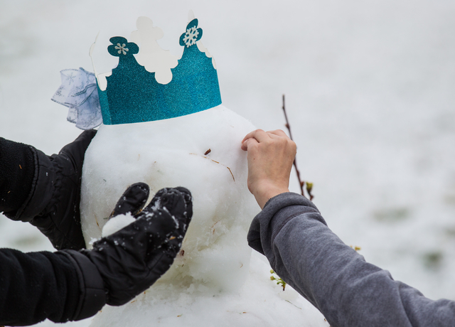 Eighteen-year-old Celestine Magallanes, left, and Kennedy Childress, 17, work on building a snowman at Gardens Park in the Summerlin area of Las Vegas on Monday, Feb. 23, 2015. Parts of Summerlin ...