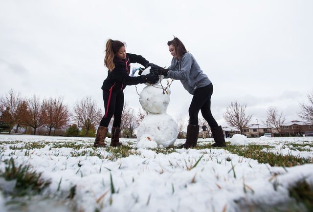 Eighteen-year-old Celestine Magallanes, left, and Kennedy Childress, 17, work on building a snowman at Gardens Park in the Summerlin area of Las Vegas on Monday, Feb. 23, 2015. Parts of Summerlin ...