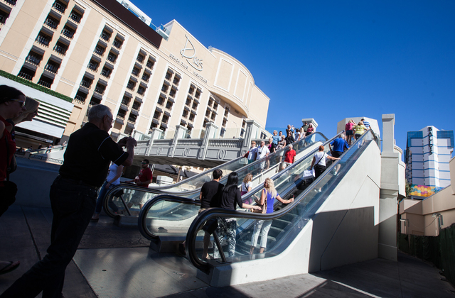 People take an escalator up to a pedestrian bridge to cross Flamingo Road on Las Vegas Boulevard near Bally's hotel-casino in Las Vegas on Wednesday, Oct. 29, 2014. (Chase Stevens/Las Vegas Review ...