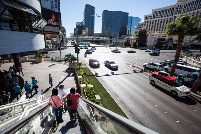 People take an escalator down from a pedestrian bridge to cross Las Vegas Boulevard near Flamingo Road on outside of The Cromwell hotel-casino in Las Vegas on Wednesday, Oct. 29, 2014. (Chase Stev ...