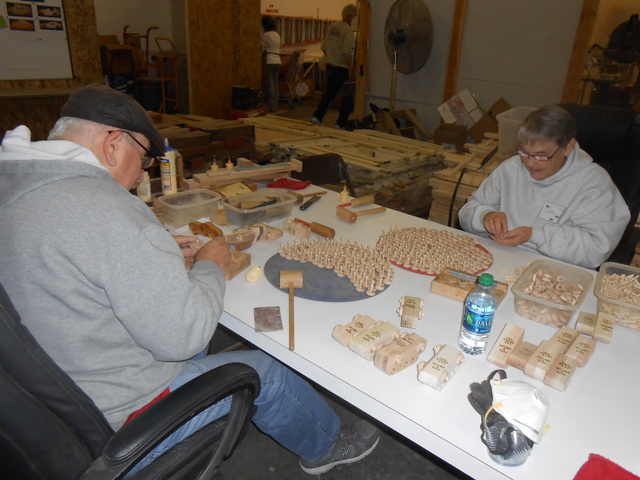 Toys 4 Smiles volunteers Vince McNeil, left, and Toni Woodson assemble wheels and axles for toy cars in the nonprofit's wood shop Dec. 30, 2014. The organization relies on the generosity of others ...