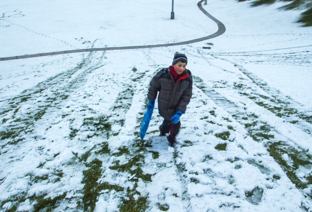 Ruben De La Rosa trudges up a hill while sledding at Willows Park in Summerlin on Monday, Feb 23, 2015. A couple inches of snow fell overnight in the higher levels of the Las Vegas Valley.  (Jeff  ...