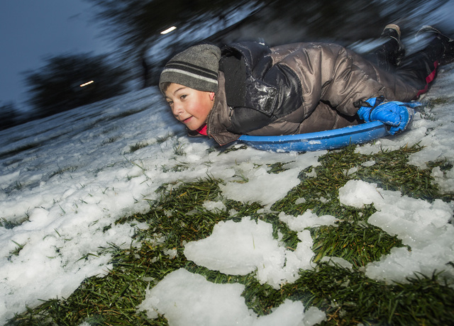 Ruben De La Rosa sledding down a hill at Willows Park in Summerlin on Monday, Feb 23, 2015. A couple inches of snow fell overnight in the higher levels of the Las Vegas Valley.  (Jeff Scheid/Las V ...