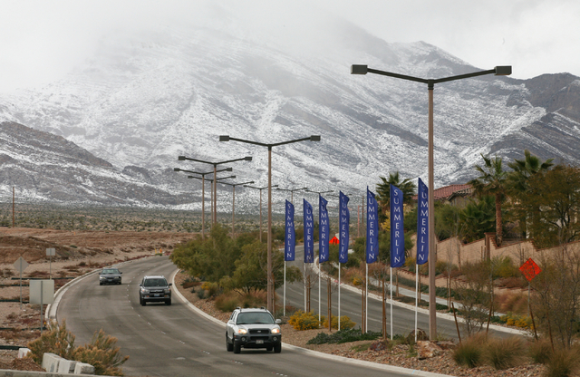 Cars travel along Sky Vista Drive and snowfall can be seen at Red Rock Canyon National Conservation Area Monday, Feb. 23, 2015, in Las Vegas. According to Las Vegas police, three hikers were repor ...