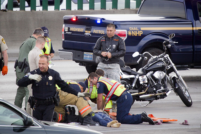 Emergency personnel try to resuscitate a woman who jumped from an overpass in the Spaghetti Bowl on Tuesday, March 17,2015. Police were notified at 5:34 pm. about the incident, which stalled rush- ...