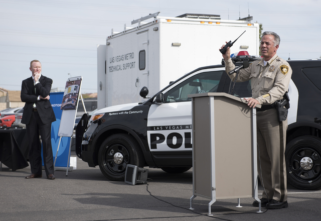 Sheriff Joe Lombardo right, shows a handset from Metro's new radio system as he speaks about a partnership with Motorola Solutions at the Enterprise Area Command in Las Vegas on Tuesday, Mar. 17, ...