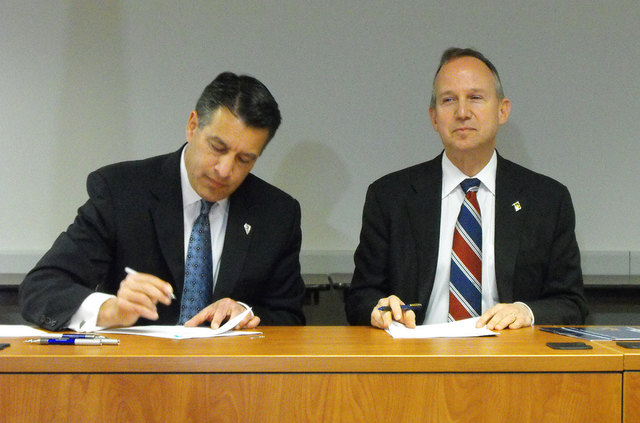 Nevada Gov. Brian Sandoval, left, and Delaware Gov. Jack Markell sign an agreement last February in Wilmington, Del., that joins the states in a partnership for online poker. (Steve Tetreault/Step ...