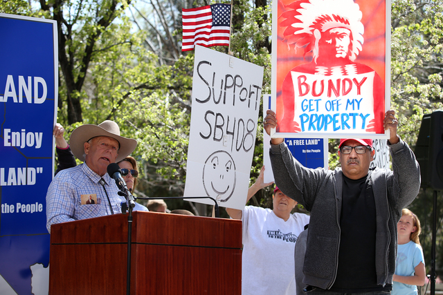 Counter-protester Tork Rains, right, moves through as Clive Bundy speaks at a rally challenging federal control of Nevada public lands outside the Legislative Building in Carson City on Tuesday, M ...