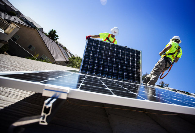 Matt Neifeld,left, and Jacy Sparkman with  Robco Electric installs solar panels at a home in northwest Las Vegas on Friday March 13, 2015. The company estimated that the 17 panel  4.675 KWDC solar ...