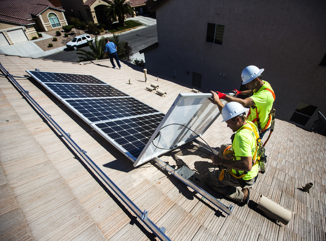 Jacy Sparkman, left, and Matt Neifeld with Robco Electric installs solar panels at a home in northwest Las Vegas on Friday March 13, 2015. The company estimated that the 17 panel 4.675 KWDC sola ...