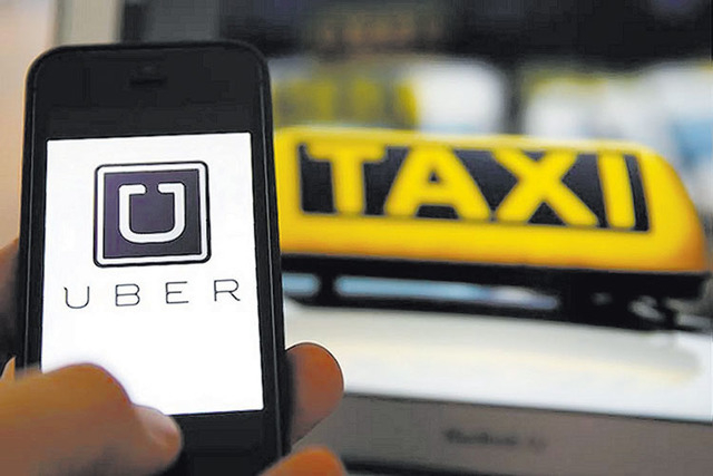 An illustration picture shows the logo of car-sharing service app Uber on a smartphone. (Kai Pfaffenbach/Reuters)