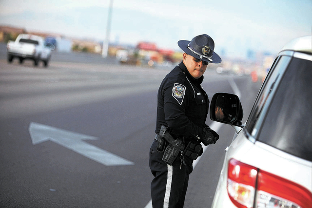 Trooper Loy Hixson of the Nevada Highway Patrol speaks with a man he pulled over for speeding along Interstate 15 south of Las Vegas Saturday, Jan. 11, 2014. (John Locher/Las Vegas Review-Journal)