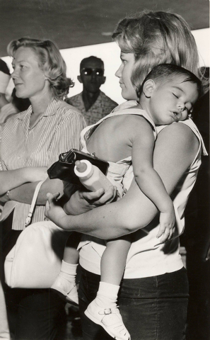A woman hold a toddler as she waits in line to purchase concert ticket to see the British rock 'n' roll band The Beatles at the Las Vegas Convention Center, June 29, 1964. (Terry Todd/Las Vegas Re ...
