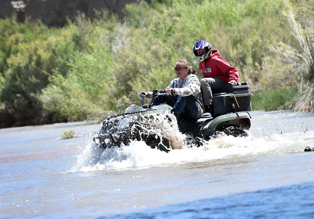 Party goers use a ATV to cross the Virgin River during an event at the Bundy Ranch in Bunkerville on Saturday, April 11, 2015. Rancher Cliven Bundy is hosting barbecue celebrating the one-year ann ...