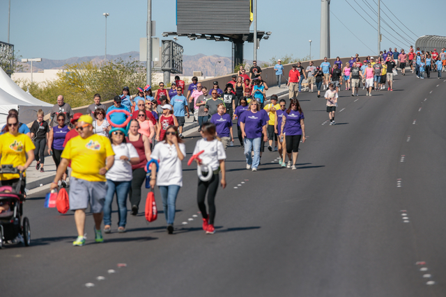 A crowd of participants walk back across the overpass on West Sunset road as part of the course for the Aid for AIDS of Nevada (AFAN) hosts the 25th Annual AIDS Walk Las Vegas at Town Square Las V ...