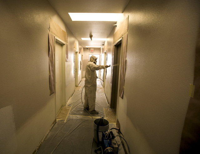 A worker paints in the hallway of 211 at  211 8th Street on Thursday, April 16, 2015. Downtown Project will soon be renting small renovated apartments in the 315­-unit complex in downtown Las ...