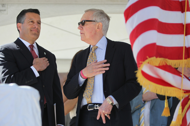 Nevada Gov. Brian Sandoval, left, and U.S. Sen. Harry Reid, D,Nev., recite the Pledge of Allegiance during the ground breaking ceremony for the I-11 Boulder City bypass project in Boulder City, Ne ...