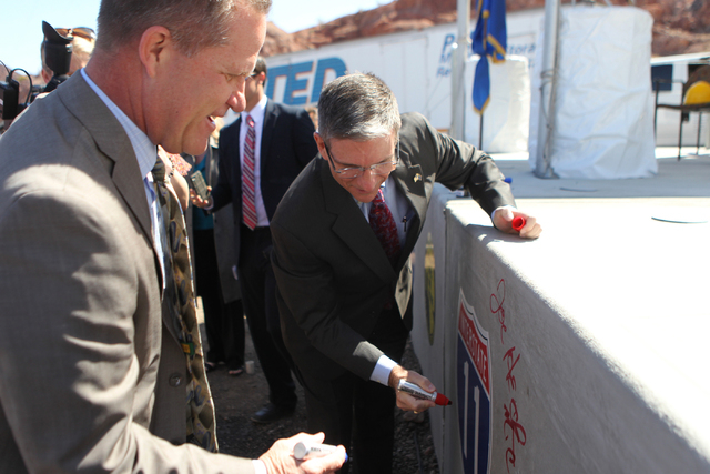 Nevada Lt. Gov. Mark Hutchinson, left, waits for U.S. Rep. Joe Heck, R-Nev., to sign a concrete box culvert during the ground breaking ceremony for the I-11 Boulder City bypass project in Boulder  ...