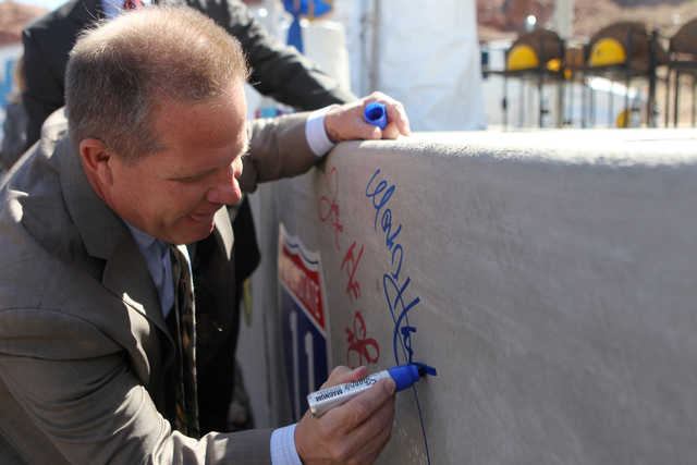 Nevada Lt. Gov. Mark Hutchinson signs a concrete box culvert during the ground breaking ceremony for the I-11 Boulder City bypass project in Boulder City, Nev., Monday, April 6, 2015. (Erik Verduz ...