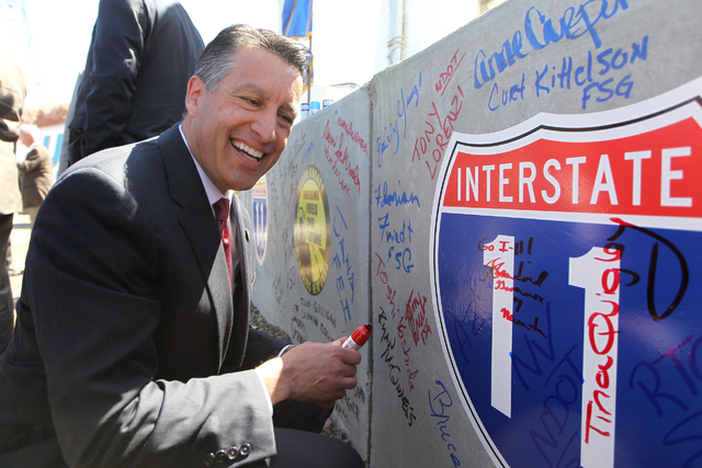 Nevada Gov. Brian Sandoval smiles after signing a concrete box culvert during the ground breaking ceremony for the I-11 Boulder City bypass project in Boulder City, Nev., Monday, April 6, 2015. (E ...