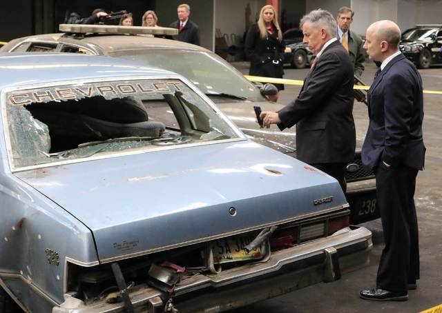 Cuyahoga County prosecutor Tim McGinty (L) takes a photo with his cell phone at a mock up of the crime scene during the manslaughter trial for a police officer in Cleveland, Ohio April 10, 2015. M ...