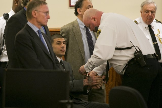 A court officer places handcuffs on the wrists of former NFL player Aaron Hernandez after the guilty verdict was read during his murder trial at the Bristol County Superior Court in Fall River, Ma ...
