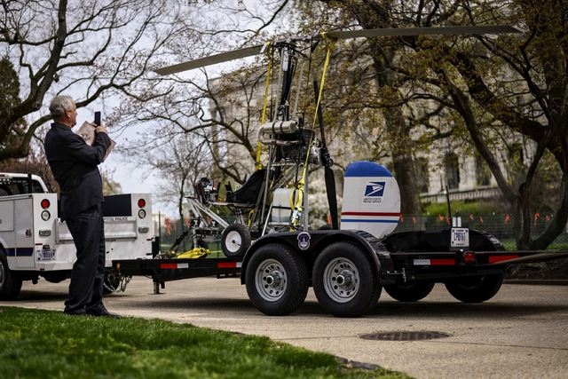 A man takes pictures of a gyro copter that was flown onto the grounds of the U.S. Capitol as it is towed from the west front lawn in Washington, in this file photo taken April 15, 2015.  Douglas M ...