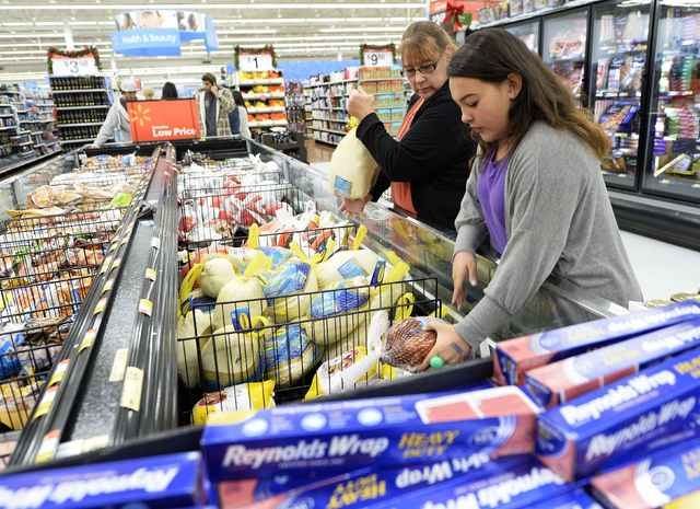 Tina Corpus and her daughter Christina shop for a turkey at a Walmart store in Los Angeles, California, United States, in this file photo taken November 26, 2013. The outbreak of fatal bird flu cu ...