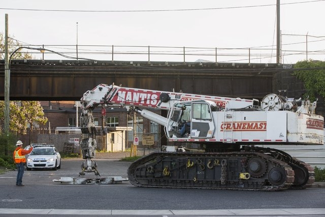 A worker gestures as a large crane arrives to help with the aftermath of a derailed Amtrak train in Philadelphia, Pennsylvania, May 13, 2015. (Reuters/Lucas Jackson)